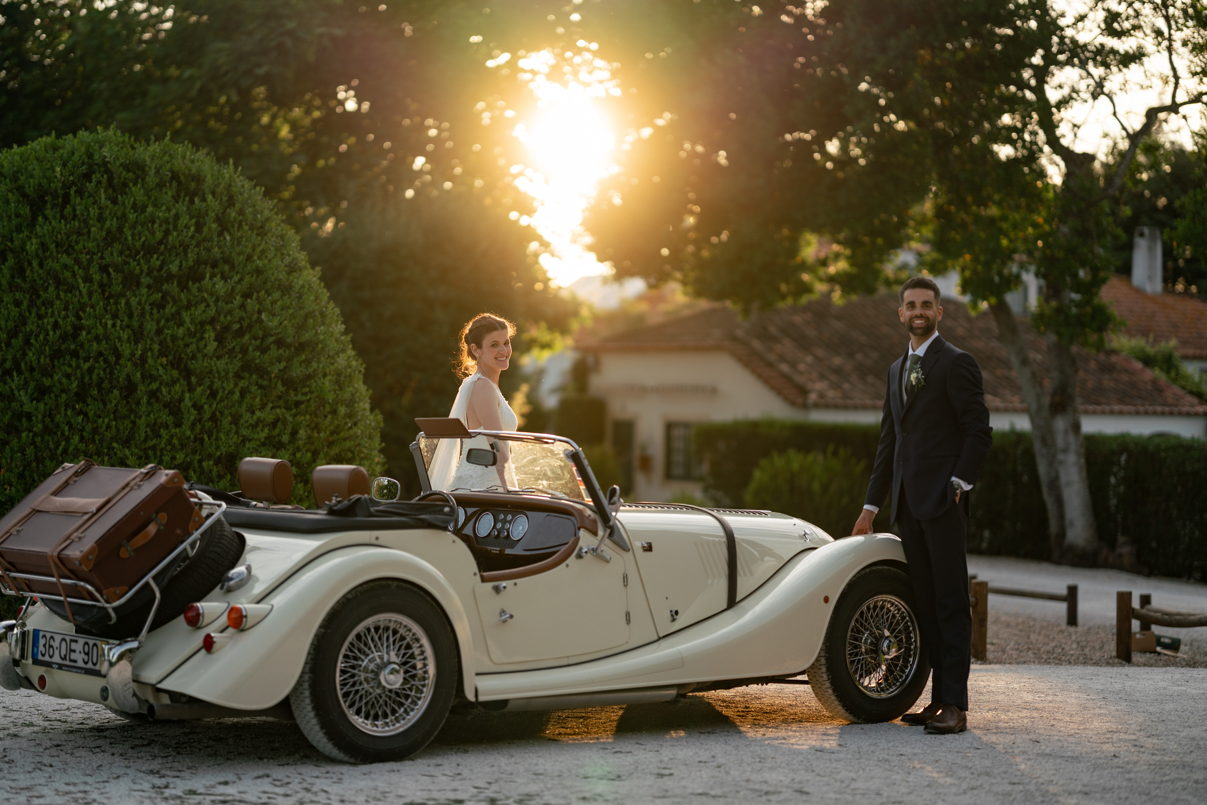 Noivos junto a um automóvel clássico ao pôr do sol, num casamento em Itália